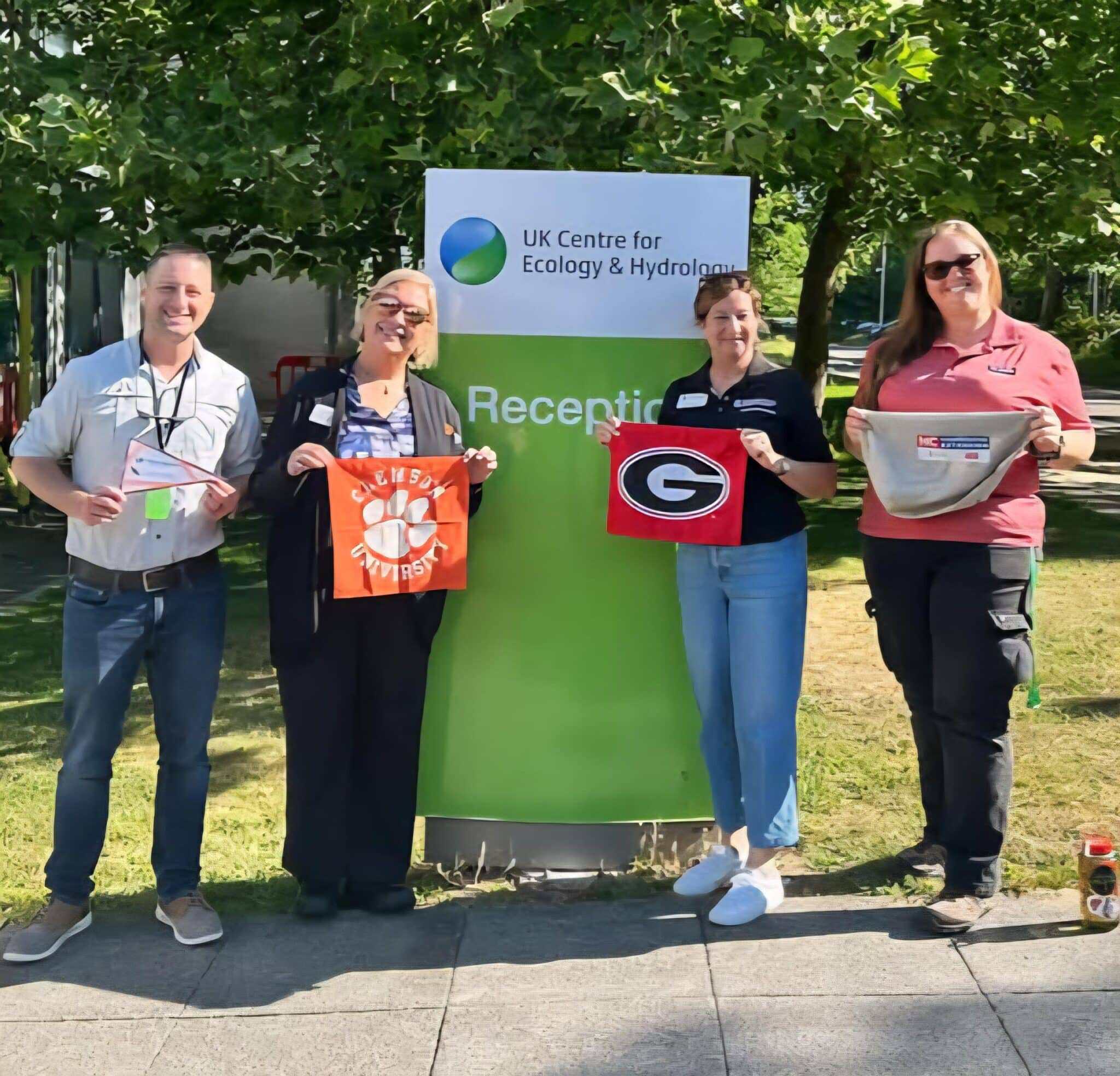 Census coordinators holding their university flags during a visit to London.